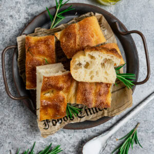 Fluffige Foccacia mit Übernachtgare geschnitten auf einem Blech serviert