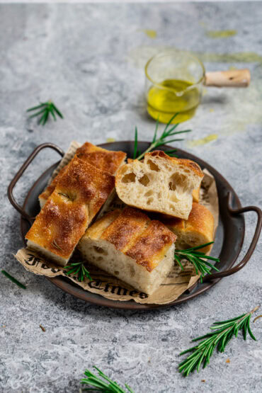 Fluffige Foccacia mit Übernachtgare geschnitten auf einem Blech serviert