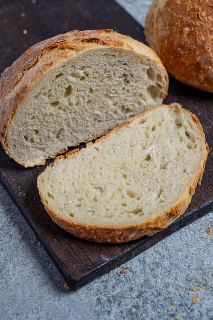 Angeschnittenes No Knead Bread und eine Scheibe Brot mit fluffiger Krume