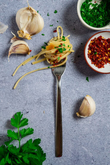 Klassische Spaghetti Aglio e Olio wie in Italien. angerichtet auf einer Gabel