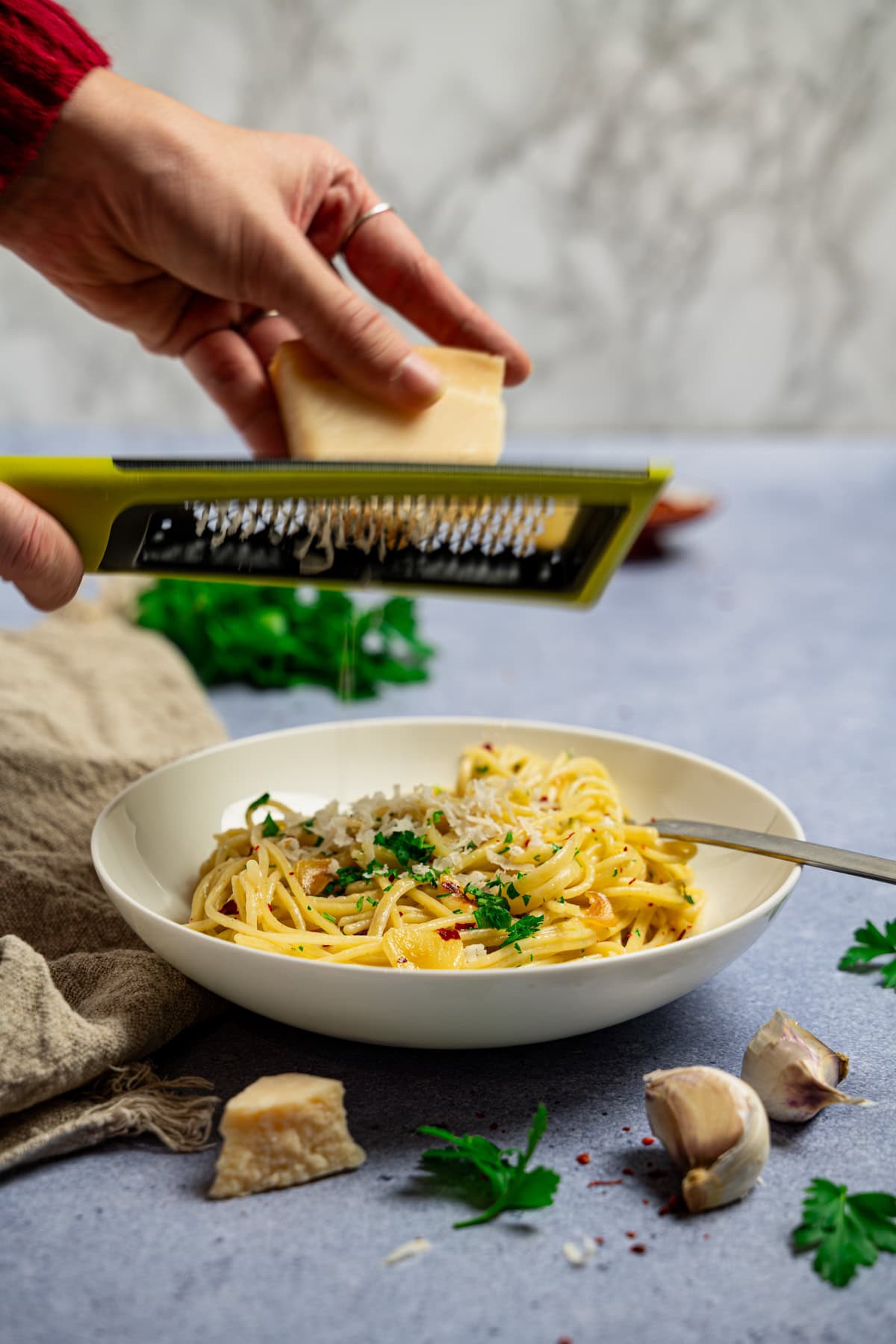 Klassische Spaghetti Aglio e Olio wie in Italien, auf einem weißen Teller, mit Parmesan bestreut