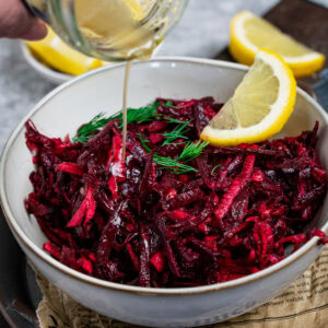 Dressing aus Honig, Zitronensaft und Olivenöl wird über deinen Rote Bete Apfel Salat gegossen