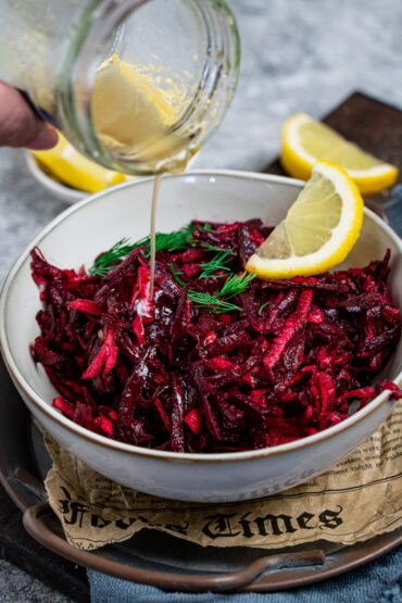 Dressing aus Honig, Zitronensaft und Olivenöl wird über deinen Rote Bete Apfel Salat gegossen