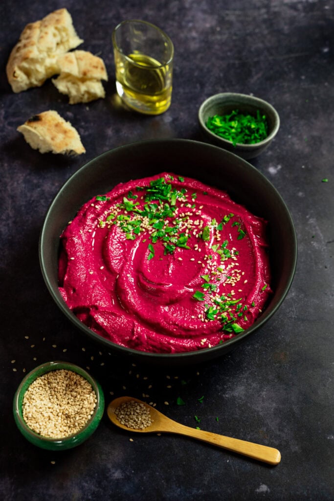 Cremiger Rote Bete Hummus garniert mit Olivenöl, Petersilie und Sesam