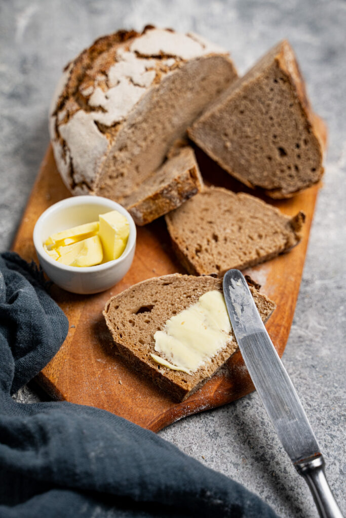 Frisches Sauerteigbrot mit Butter auf Holzbrett