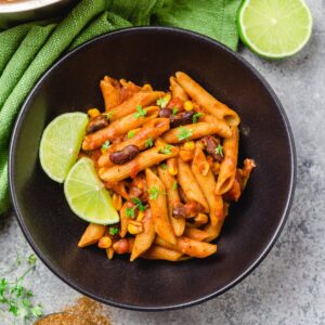 Tex Mex Pasta in weißer Schüssel, garniert mit Limette