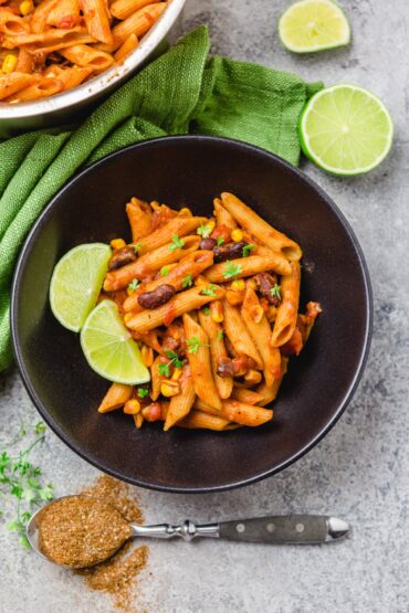 Tex Mex Pasta in weißer Schüssel, garniert mit Limette