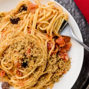 Pasta Napoletana mit Oliven und Semmelbröseln auf Teller