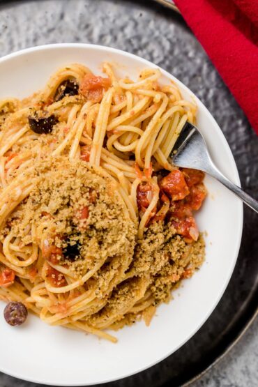Pasta Napoletana mit Oliven und Semmelbröseln auf Teller
